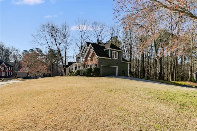 view of yard with an attached garage and driveway