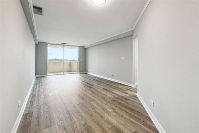 unfurnished room with hardwood / wood-style floors, ornamental molding, and floor to ceiling windows