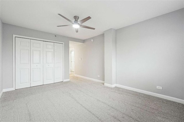 unfurnished bedroom with ceiling fan, carpet flooring, and a closet