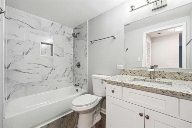 full bathroom featuring tiled shower / bath, wood-type flooring, vanity, and toilet