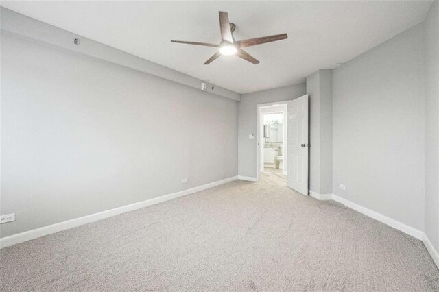 unfurnished bedroom featuring ceiling fan, light colored carpet, and ensuite bathroom