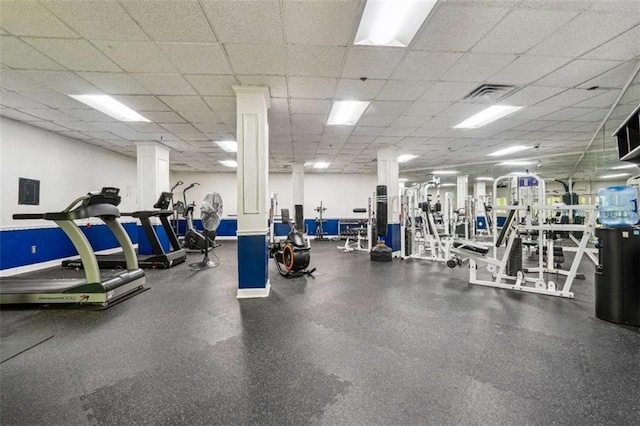 workout area featuring a paneled ceiling and ornate columns