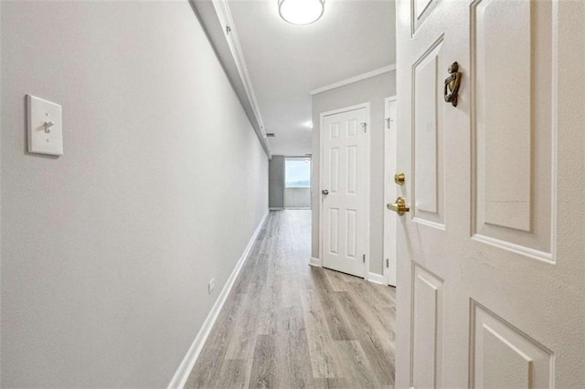 hall with crown molding and light hardwood / wood-style floors