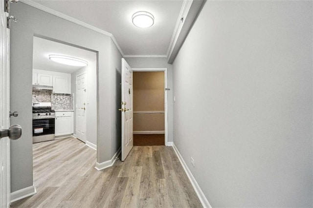 hallway featuring ornamental molding and light wood-type flooring