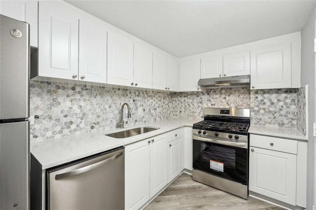 kitchen with stainless steel appliances, white cabinetry, sink, and decorative backsplash