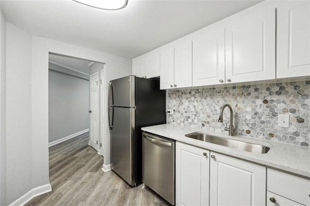 kitchen featuring white cabinetry, sink, backsplash, and appliances with stainless steel finishes