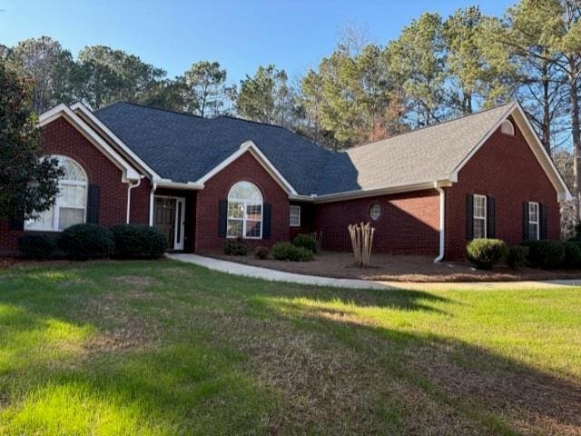 ranch-style home featuring a front lawn and brick siding