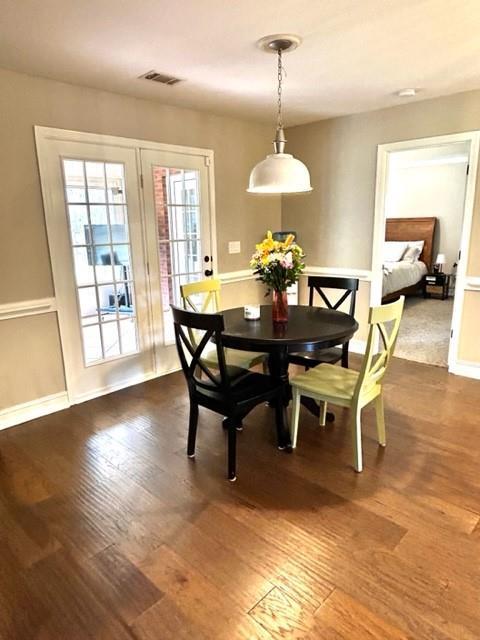 dining room with baseboards, visible vents, and dark wood finished floors