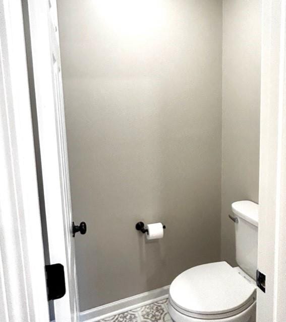 bathroom with baseboards and toilet