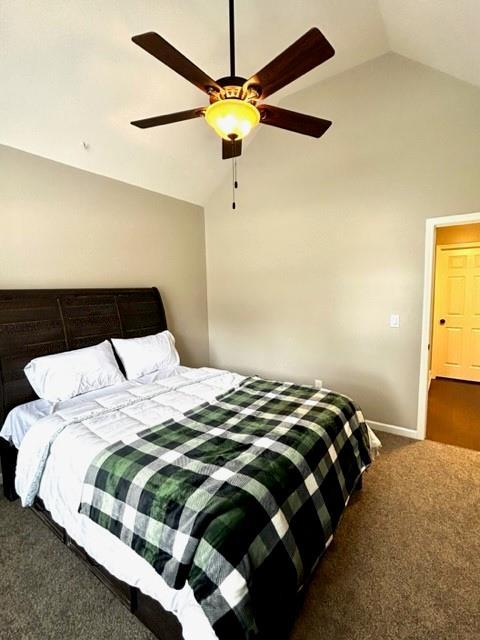 bedroom with carpet flooring, vaulted ceiling, baseboards, and ceiling fan