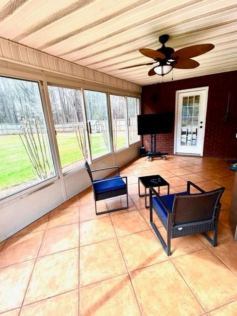 unfurnished sunroom with a ceiling fan