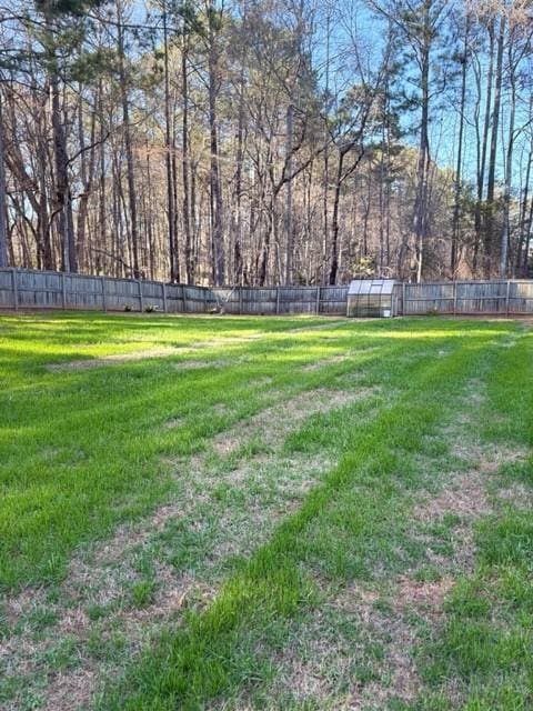 view of yard with a fenced backyard, an exterior structure, and an outdoor structure