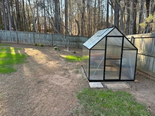 view of greenhouse featuring a fenced backyard