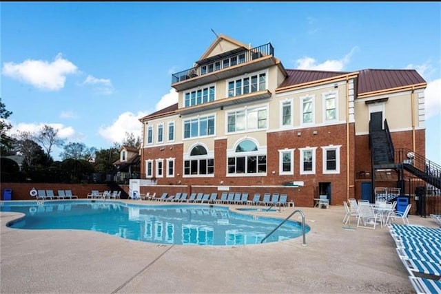 pool with a patio and fence