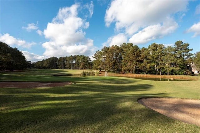 surrounding community with golf course view and a lawn