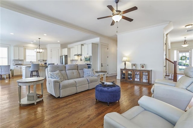 living area with crown molding, baseboards, dark wood-type flooring, and recessed lighting