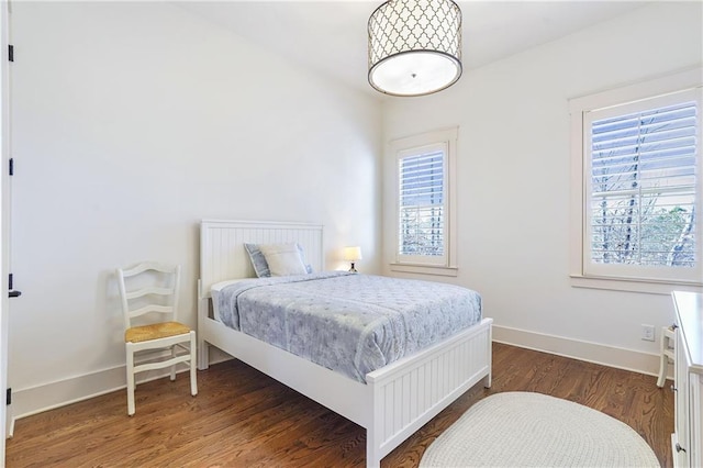 bedroom featuring dark wood finished floors and baseboards