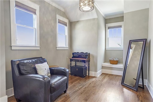 sitting room with a notable chandelier, baseboards, ornamental molding, and wood finished floors