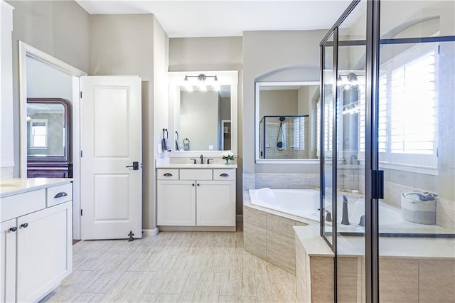 full bath featuring a shower stall, vanity, and a bath