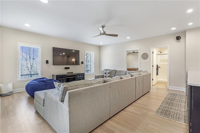 living room with recessed lighting, light wood-style flooring, and baseboards