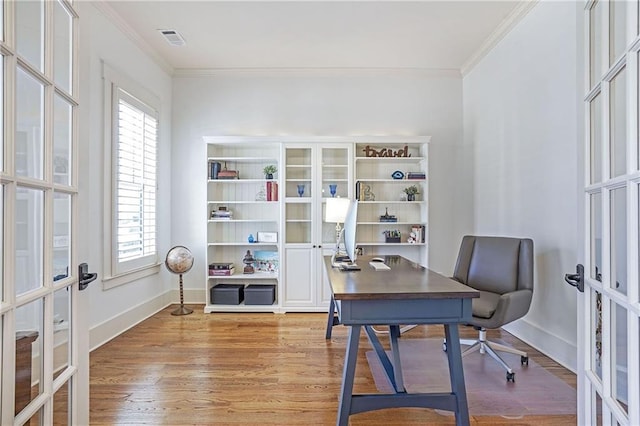 office space featuring light wood finished floors, visible vents, ornamental molding, and french doors