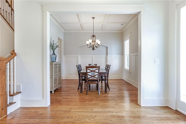 dining room with an inviting chandelier, light wood-style flooring, coffered ceiling, and beamed ceiling