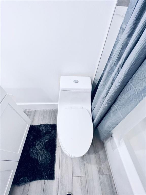 bathroom with hardwood / wood-style flooring and toilet