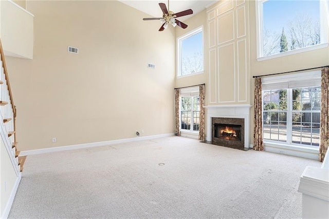 3505 Belridge Ln, Smyrna, GA 30080 - unfurnished living room featuring a towering ceiling, light colored carpet, ceiling fan, a premium fireplace, and stairway