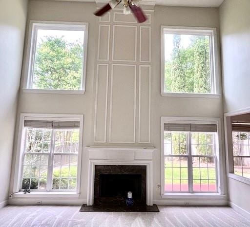 3505 Belridge Ln, Smyrna, GA 30080 - unfurnished living room featuring a fireplace, a towering ceiling, a ceiling fan, and baseboards