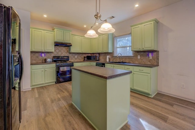 kitchen with sink, light hardwood / wood-style floors, a kitchen island, and black appliances