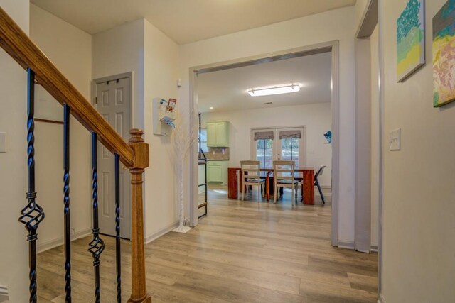 hallway with french doors and light hardwood / wood-style floors