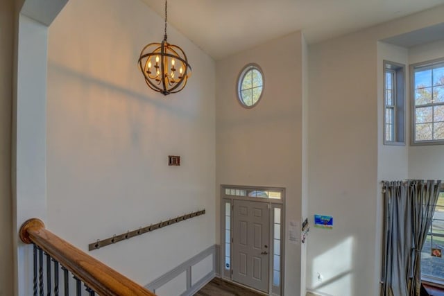 foyer with hardwood / wood-style flooring, plenty of natural light, and a notable chandelier