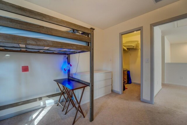 carpeted bedroom with a walk in closet