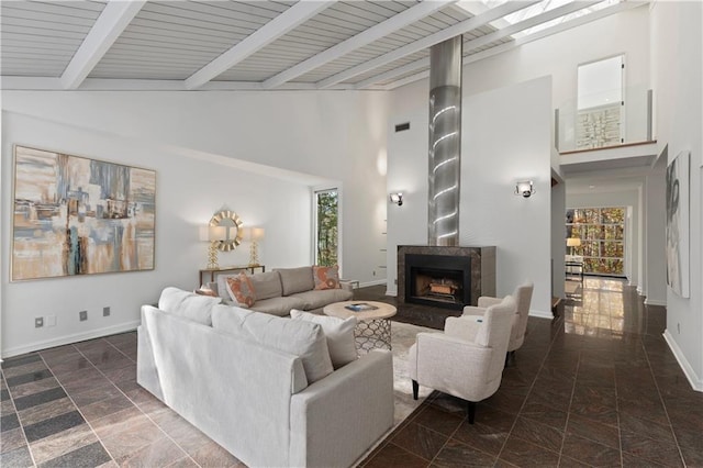 living room featuring beam ceiling, a tile fireplace, and a high ceiling