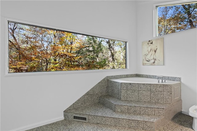 bathroom featuring a relaxing tiled tub