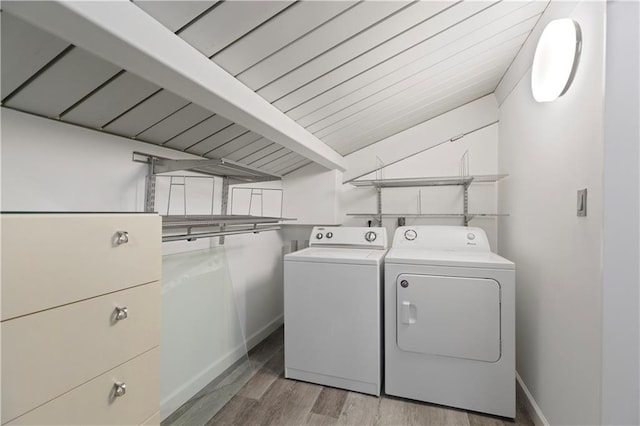 laundry area with separate washer and dryer, hardwood / wood-style floors, and wooden ceiling