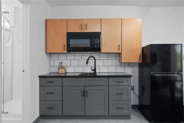 kitchen with gray cabinetry, decorative backsplash, and black appliances