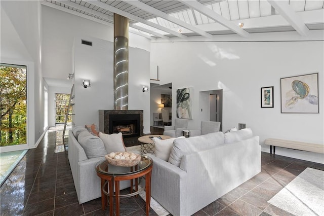 living room with beamed ceiling and a high ceiling