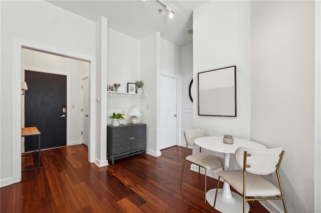 dining room featuring breakfast area, dark wood finished floors, and baseboards