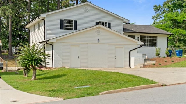 3735 Benchmark Dr, Atlanta, GA 30349 - split level home featuring a front lawn, concrete driveway, and a garage