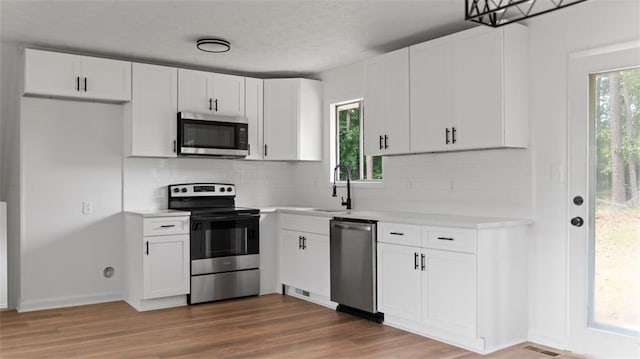 3735 Benchmark Dr, Atlanta, GA 30349 - kitchen with appliances with stainless steel finishes, light countertops, a sink, and tasteful backsplash