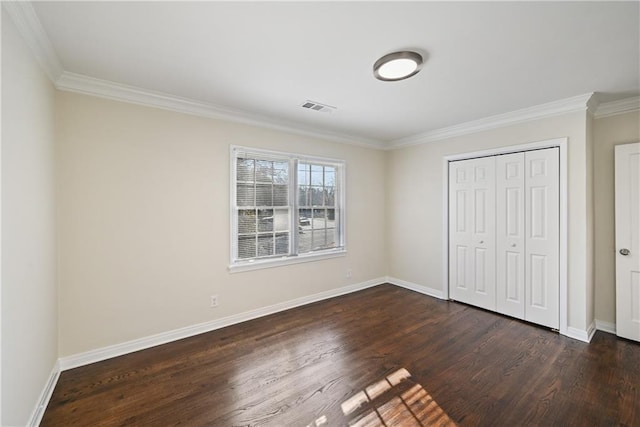 unfurnished bedroom with ornamental molding, dark hardwood / wood-style floors, and a closet