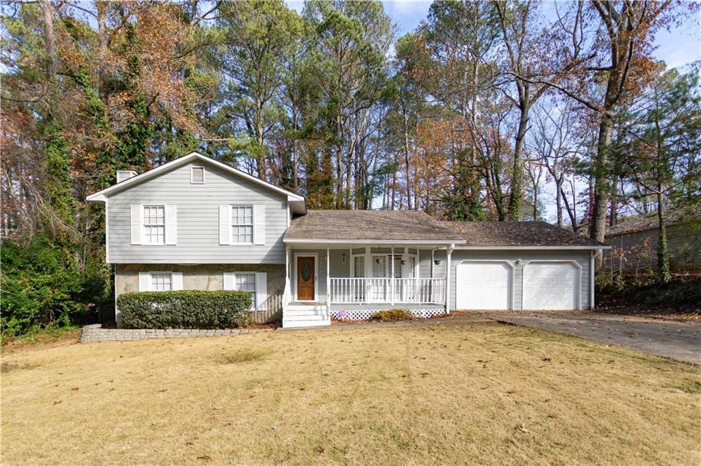 split level home with a front yard, a porch, and a garage