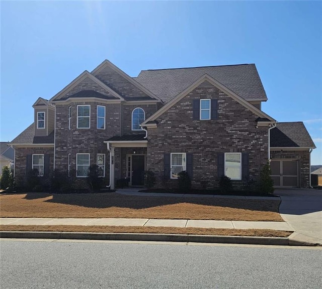 view of front facade with concrete driveway and brick siding