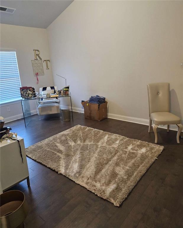 sitting room with wood finished floors, visible vents, and baseboards