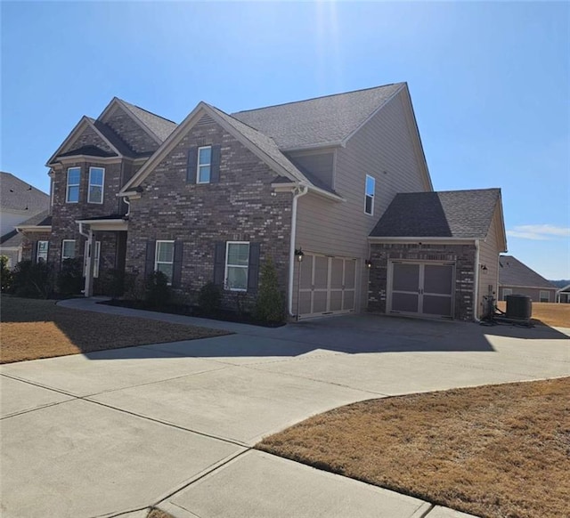 view of front of house with brick siding, driveway, an attached garage, and central air condition unit