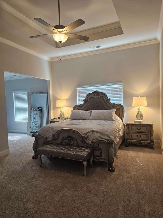 bedroom featuring carpet floors, ornamental molding, a raised ceiling, and visible vents