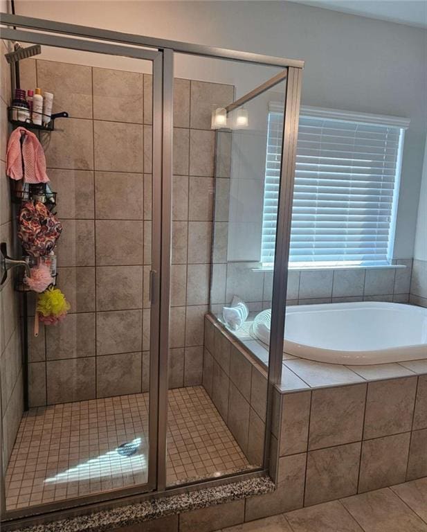 bathroom featuring a stall shower, tile patterned flooring, and a bath