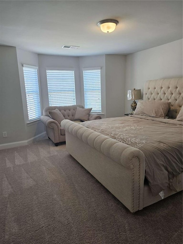 bedroom featuring baseboards, multiple windows, visible vents, and carpet flooring