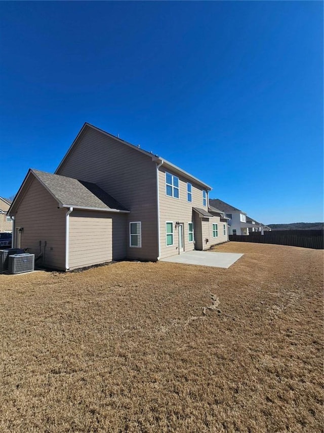 back of property featuring a yard, fence, central AC unit, and a patio